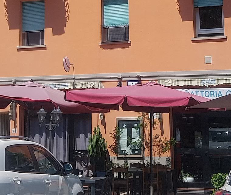 L'ingresso della Trattoria Grillini con l'insegna e gli ombrelloni bordeaux del dehors